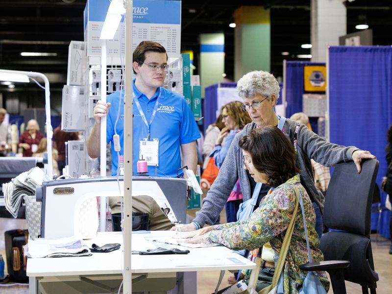 A festival team member helping visitors at a stand